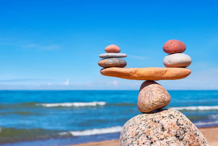 Sassi in equilibrio sulla spiaggia come simbolo di armonia nel diritto di famiglia ad Alghero